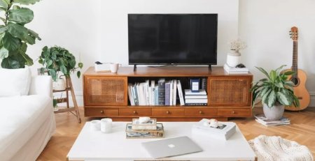 میز تلویزیون با کتاب در کنار گیتار و گل